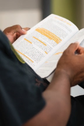 Student holding book with orange highlighted sections